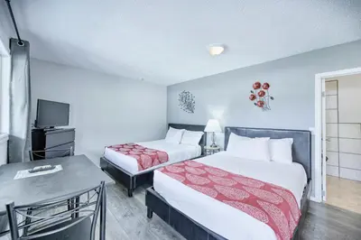 a hotel room with two beds and a television at Maple Leaf Motel & RV Park Resort in Oliver