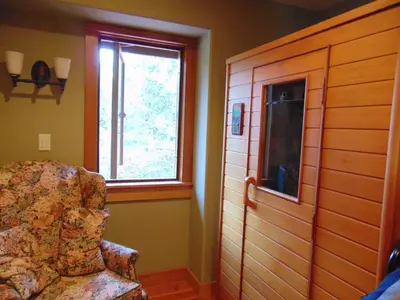 a living room with a chair and a window at Paradise Acres Ranch in Nanoose Bay