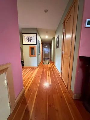 an empty hallway with wooden floors and pink walls at Paradise Acres Ranch in Nanoose Bay