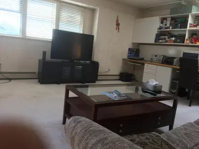 a living room with a coffee table and a flat screen tv at Vancouver Homestay Inn in Richmond