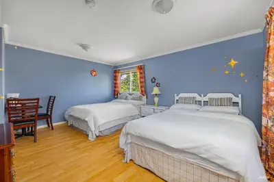 two beds in a bedroom with blue walls at Charming Family Hotel in Richmond