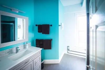 a blue bathroom with a sink and a mirror at Cloudside Hotel in Nelson