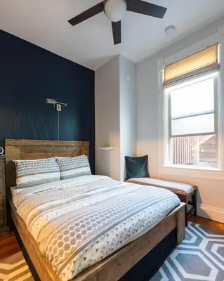 a bedroom with a large bed and a ceiling fan at Cloudside Hotel in Nelson