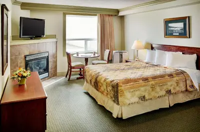 a hotel room with a bed and a fireplace at Nova Inn Peace River in Peace River
