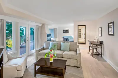 a living room with a couch and a table at Villa Eyrie Resort in Malahat