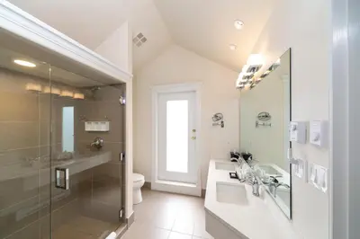 a bathroom with a shower and a sink and a toilet at Villa Eyrie Resort in Malahat