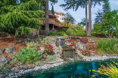 a backyard with a pool and a house at Villa Eyrie Resort in Malahat