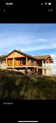 a large wooden house on top of a field at Heart West Haven in Priddis