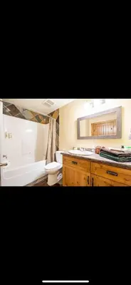 a bathroom with a tub and a toilet and a sink at Heart West Haven in Priddis