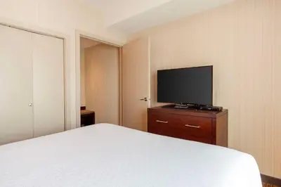 a bedroom with a bed and a flat screen tv at Best Western Plus Chateau Fort St. John in Fort Saint John