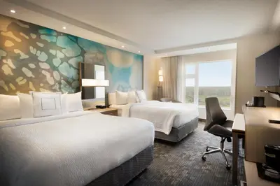 a hotel room with two beds and a window at Hotel Dene & Conference Centre in Cold Lake