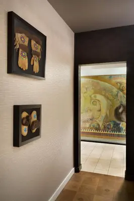 a hallway with two paintings on the wall and a doorway at Hotel Dene & Conference Centre in Cold Lake