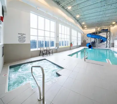 a large swimming pool with a slide in a building at Holiday Inn Express - Red Deer North by IHG in Red Deer