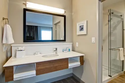 a bathroom with a sink and a mirror at Hampton Inn & Suites by Hilton Grande Prairie in Grande Prairie