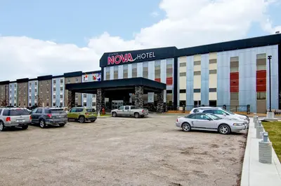 a large building with cars parked in a parking lot at Chateau Nova Yellowknife in Yellowknife