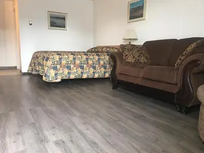 a living room with a couch and a bed at Raven Motor Inn in High Prairie