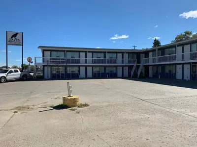 an empty parking lot in front of a building at Raven Motor Inn in High Prairie