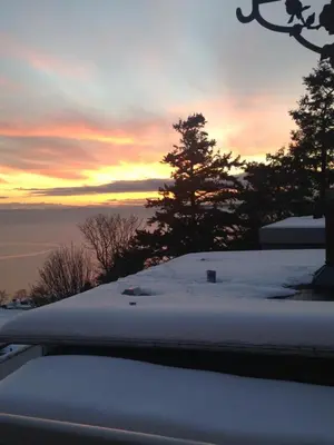 a sunset with snow on the roof of a car at Donna's Bed & Breakfast in White Rock