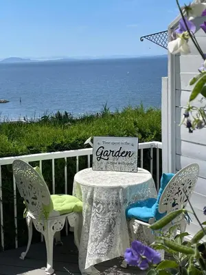 a table with two chairs and a sign on a porch at Donna's Bed & Breakfast in White Rock