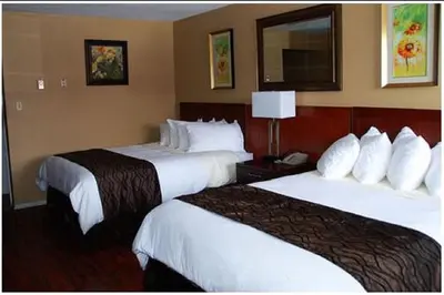 a hotel room with two beds with white sheets at Best Lodge Motel in Lloydminster