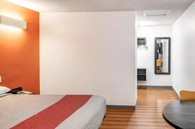 a bedroom with a bed and a table in a room at Motel 6-Fort Nelson, BC in Fort Nelson