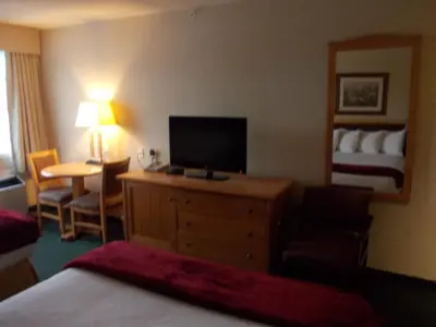 a hotel room with a bed and a flat screen tv at Rocky Inn Express in Rocky Mountain House
