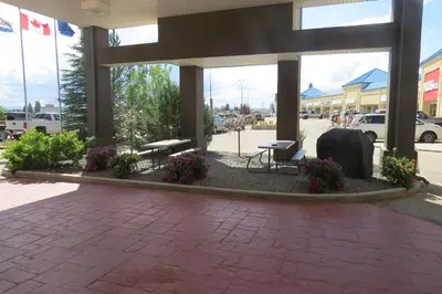 a patio in a shopping center with benches and flowers at Rocky Inn Express in Rocky Mountain House