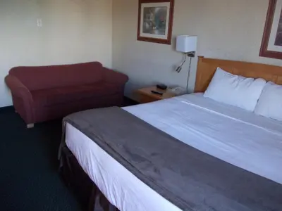 a hotel room with a bed and a chair at Rocky Inn Express in Rocky Mountain House