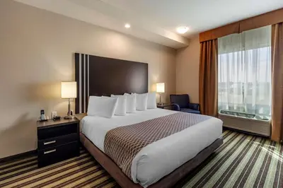 a hotel room with a large bed and a large window at Best Western Plus Drayton Valley in Drayton Valley