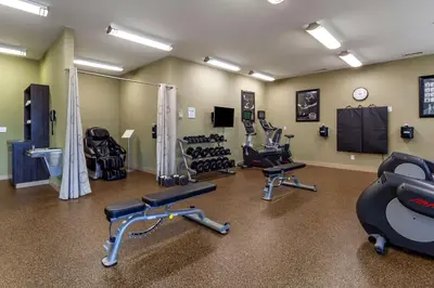 a gym with treadmills and chairs in a room at Best Western Plus Drayton Valley in Drayton Valley