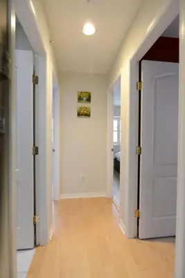 an empty hallway with a door and a hard wood floor at Marpole Guest House in Vancouver