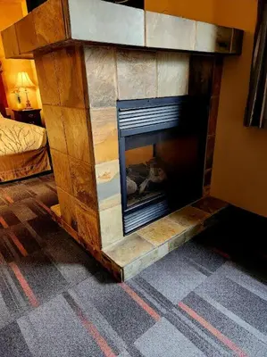 a stone fireplace in a living room with at Rundle Mountain Lodge in Canmore