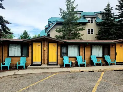 a house with blue chairs in front of it at Rundle Mountain Lodge in Canmore