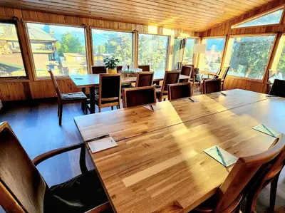 a dining room with a large wooden table and chairs at Rundle Mountain Lodge in Canmore