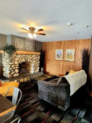 a living room with a stone fireplace and a couch at Rundle Mountain Lodge in Canmore