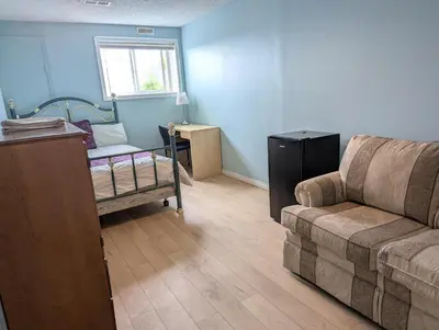 a living room with a couch and a window at Calgary Star Cozy Home in Calgary