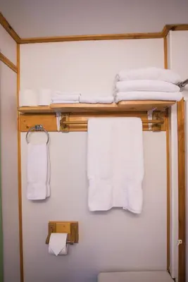 a bathroom with white towels on a shelf at Cedar Haven Cabins and Resort in Clearwater