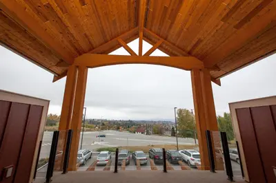 an open door to a parking lot with cars parked at Hillcrest Farm Market B&B in Kelowna