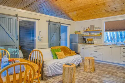 a kitchen with a bed and a table in a room at Barefoot Villas and Retreat in Christina Lake