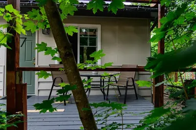 a screened porch with a table and chairs at Barefoot Villas and Retreat in Christina Lake