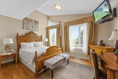 a bedroom with a wooden bed and a desk and window at Lakeshore Inn in Cold Lake