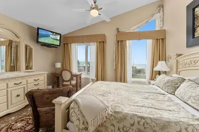 a bedroom with a bed and a tv and windows at Lakeshore Inn in Cold Lake