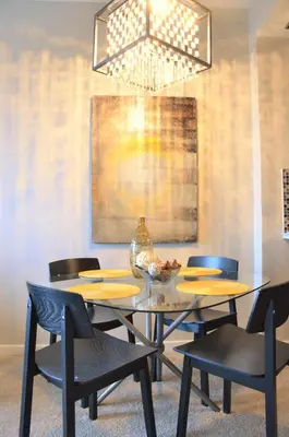 a dining room with a table and chairs and a chandelier at Monki Di Executive Suites - Alura in Calgary
