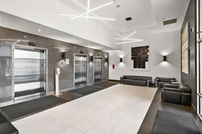 a lobby with a waiting area with black leather chairs and a waiting room at Monki Di Executive Suites - Alura in Calgary