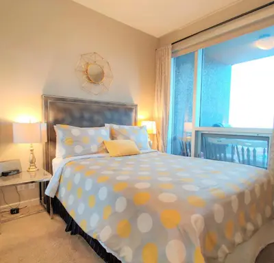 a bedroom with a bed with polka dot sheets and a window at Monki Di Executive Suites - Alura in Calgary