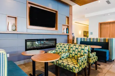 a waiting room with two chairs and a fireplace at Holiday Inn Express & Suites - West Edmonton-Mall Area by IHG in Edmonton