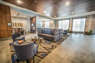 a lobby with a couch and chairs and a table at Holiday Inn Express & Suites - West Edmonton-Mall Area by IHG in Edmonton