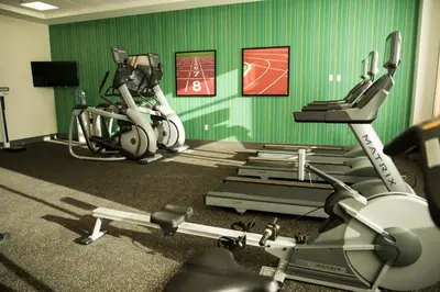 a gym with two exercise bikes and a woman on a treadmill at Holiday Inn Express & Suites - West Edmonton-Mall Area by IHG in Edmonton