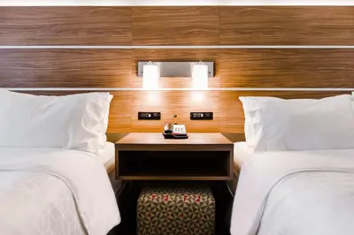 a hotel room with two beds and a nightstand between them at Holiday Inn Express & Suites - West Edmonton-Mall Area by IHG in Edmonton