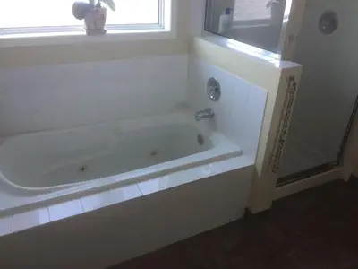 a white bathroom with a tub and a window at Brother Li Homestay in Calgary
